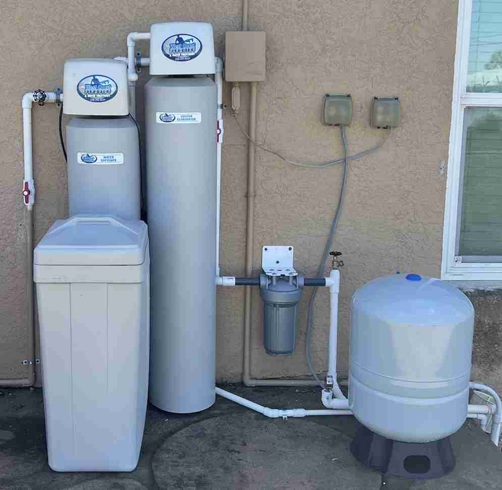 Water softener and treatment tanks installed at a home exterior