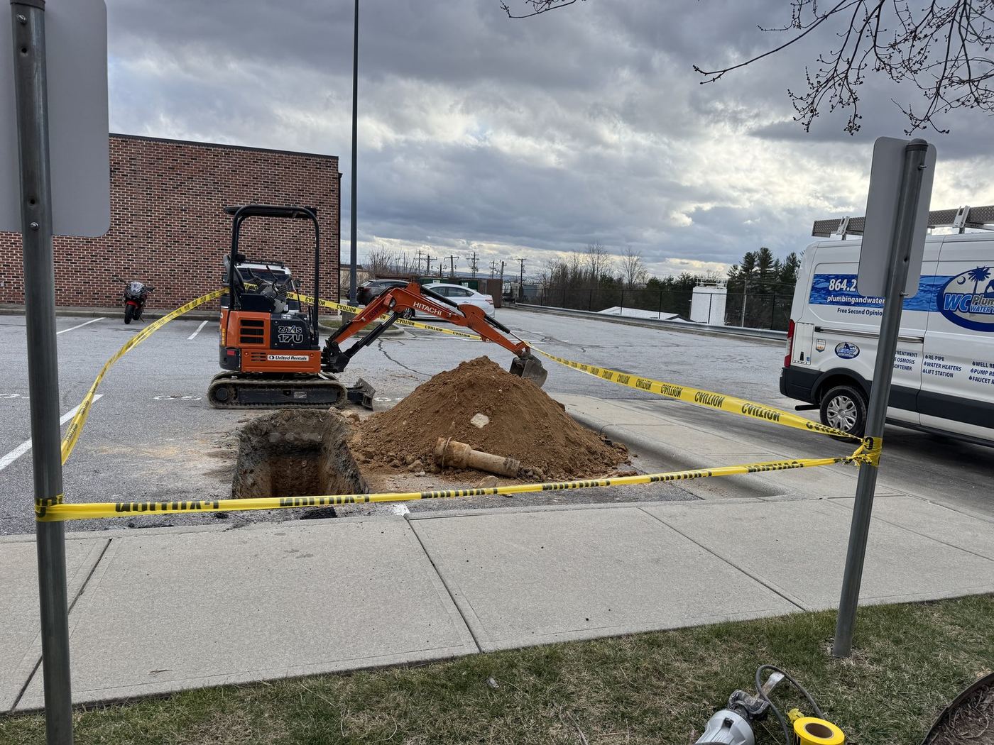 WC Plumbing van and mini excavator at a commercial dig