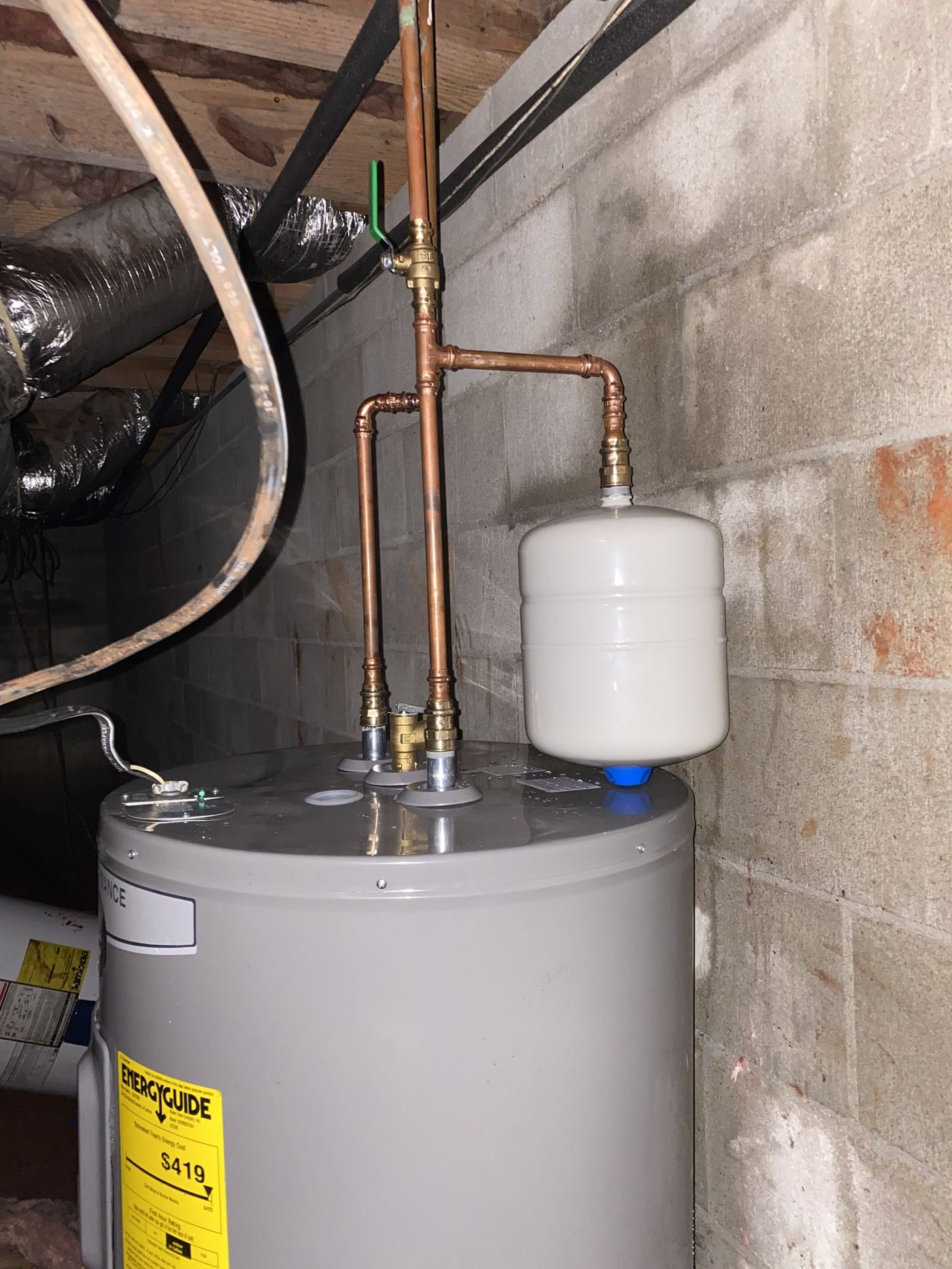 New water heater with expansion tank installed in a basement